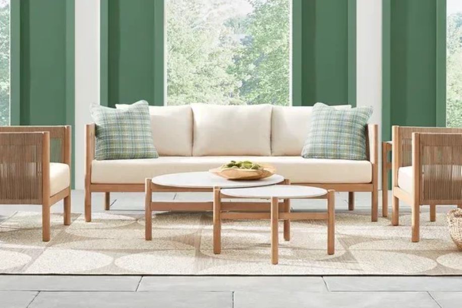Outdoor furniture set with a sofa, two chairs, and two coffee tables.

