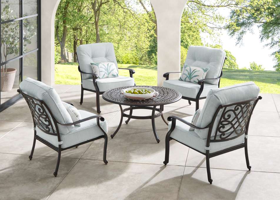 Outdoor patio furniture set with a round table and four chairs.
