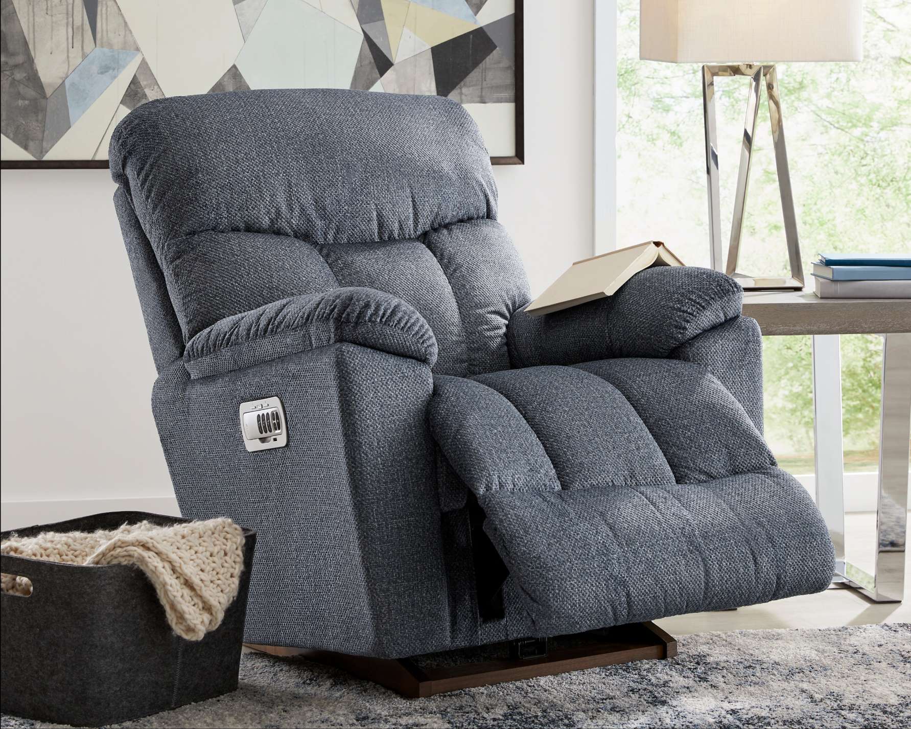 Blue recliner chair with a book on the arm.
