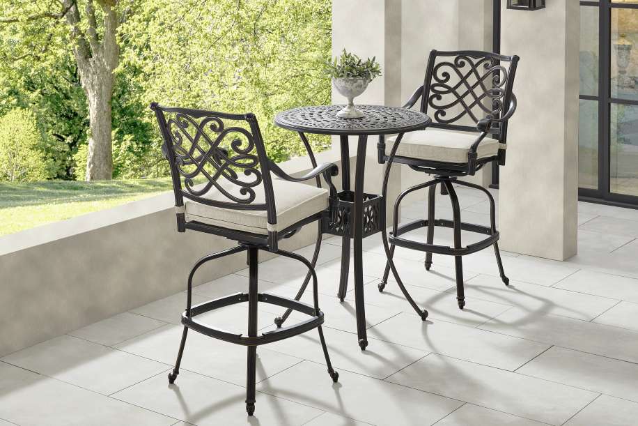 Outdoor bar set with two chairs and a small table.
