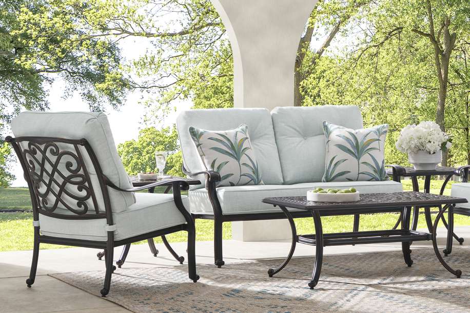 Outdoor patio furniture set with a loveseat, chair, and coffee table.
