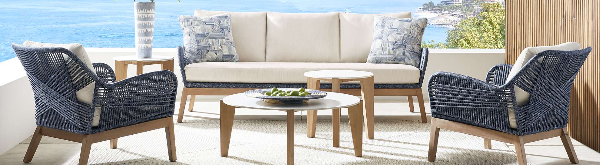 Outdoor furniture set with a sofa, two chairs, and two side tables.
