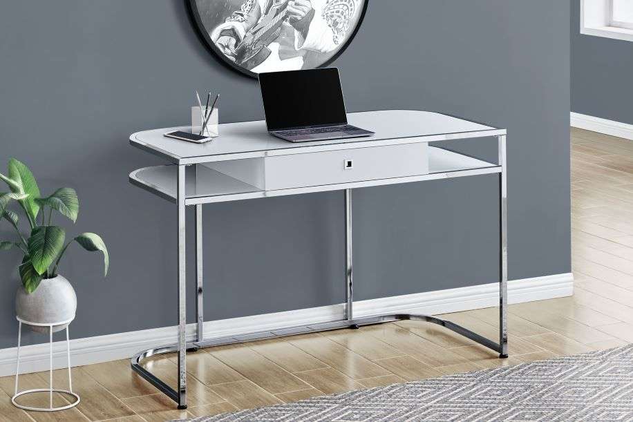 White desk with chrome legs, a laptop, and a plant.