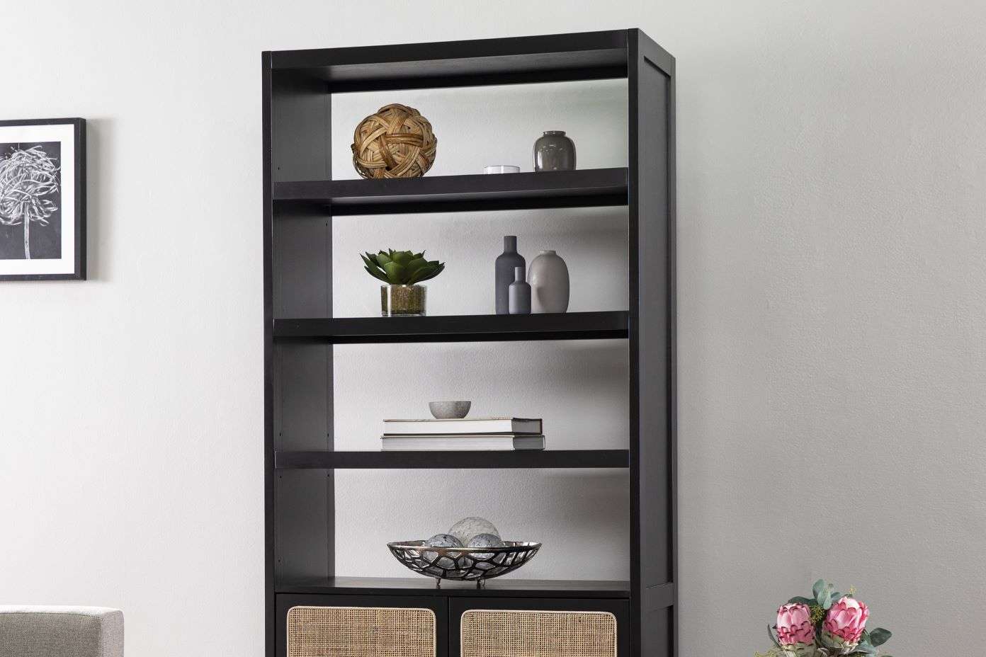 Black bookshelf with decorative items.
