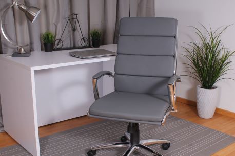 Gray office chair in front of a white desk with a laptop and a plant.
