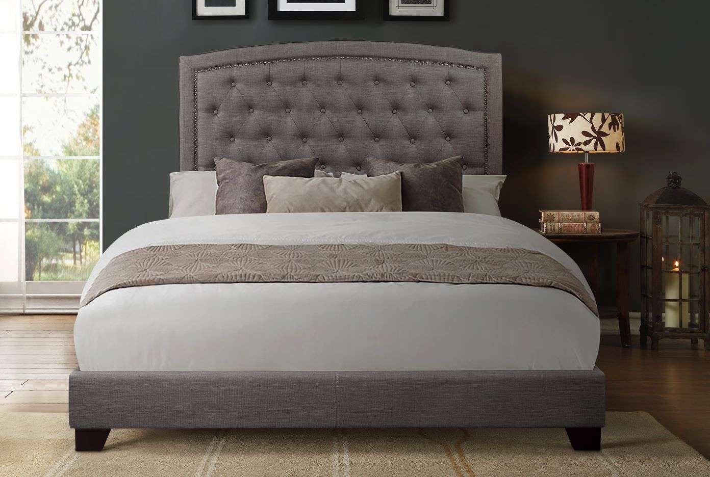 Gray upholstered bed with a tufted headboard.