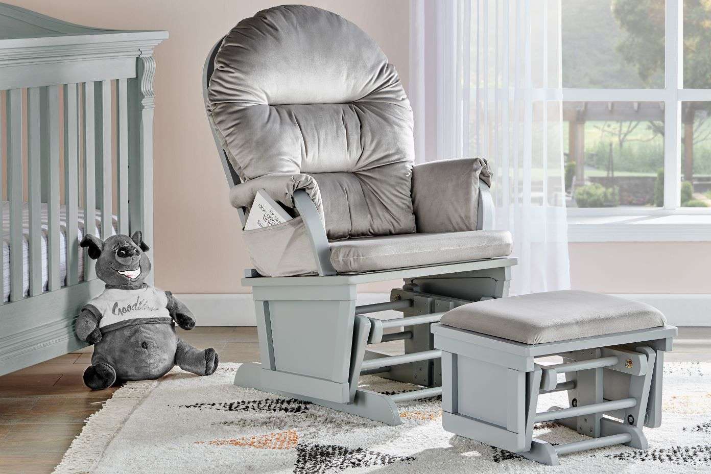 A gray glider chair with a matching ottoman in a nursery.
