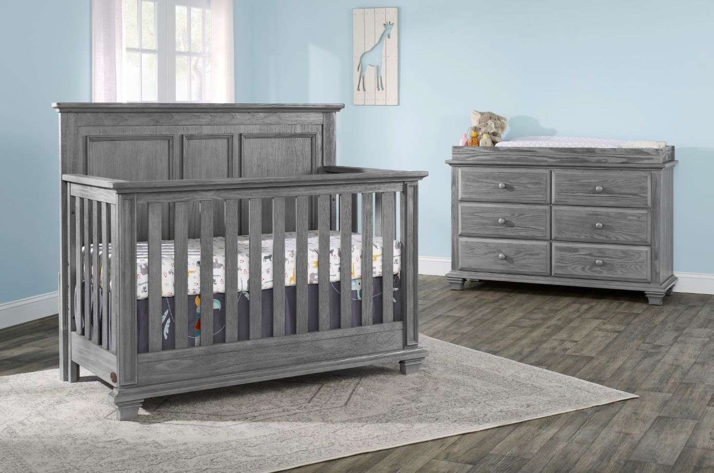 Gray crib and dresser set in a nursery.