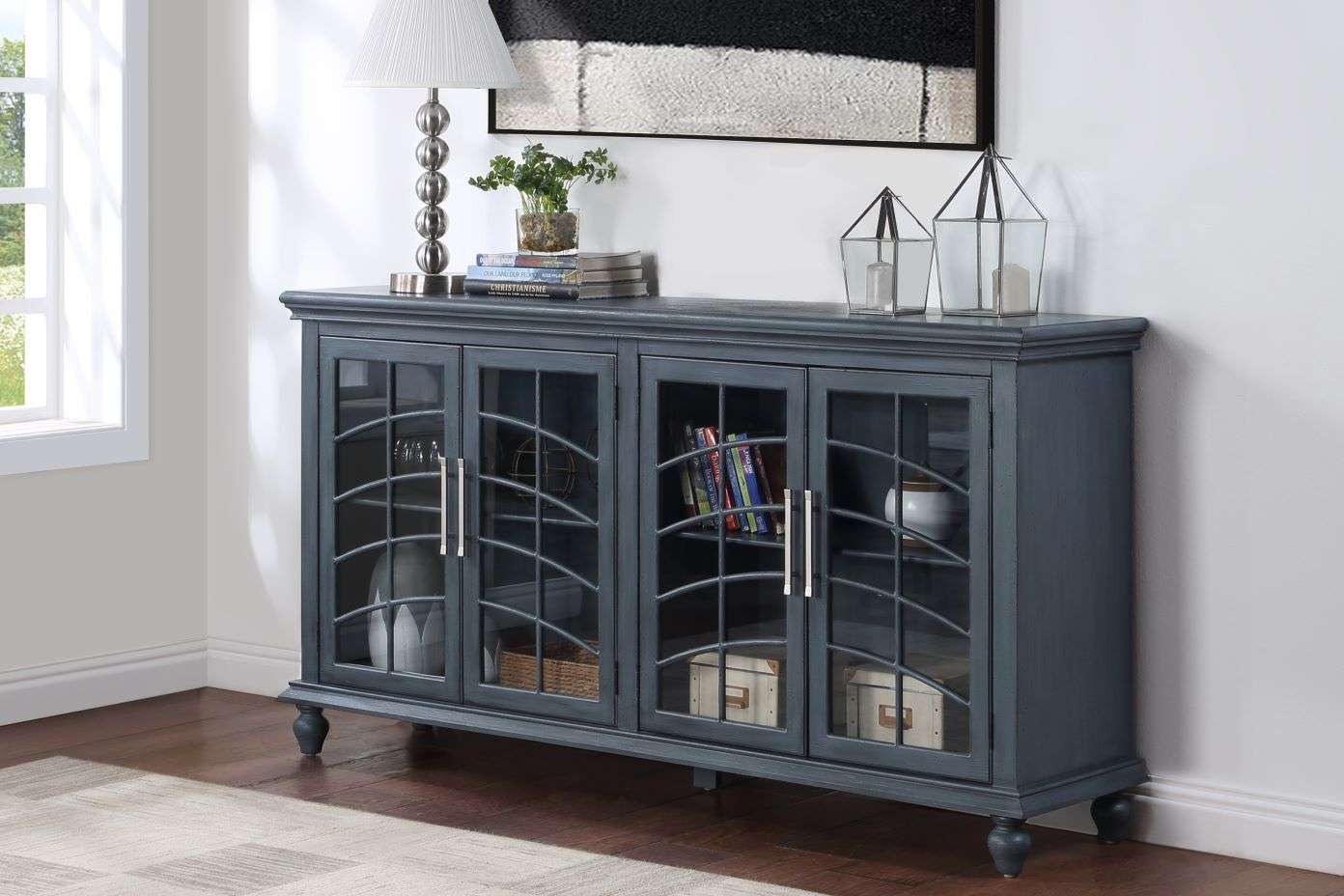 Blue cabinet with glass doors, holding books and decorative items.
