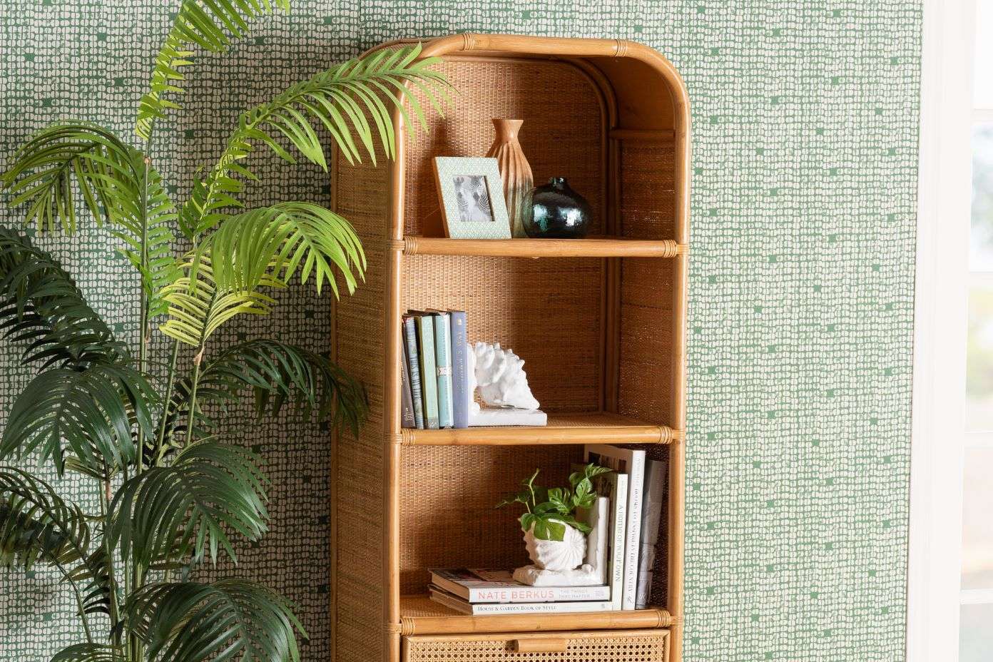 Rattan bookshelf with decorative items and books.