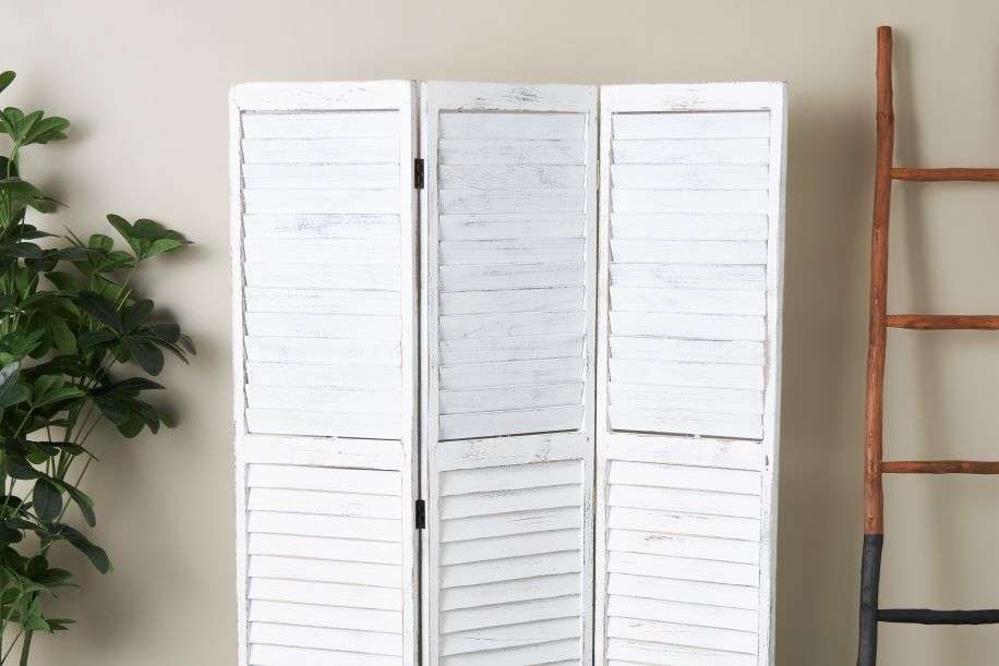White shutter screen with a wooden ladder and a green plant.
