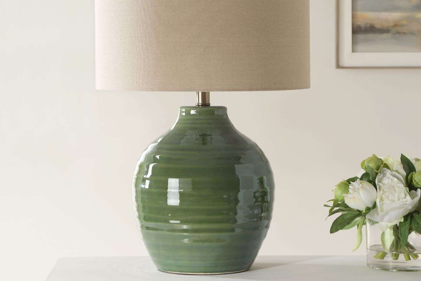 Green ceramic lamp with a beige lampshade.
