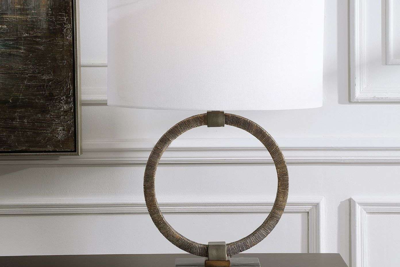 A table lamp with a circular base and a white lampshade.
