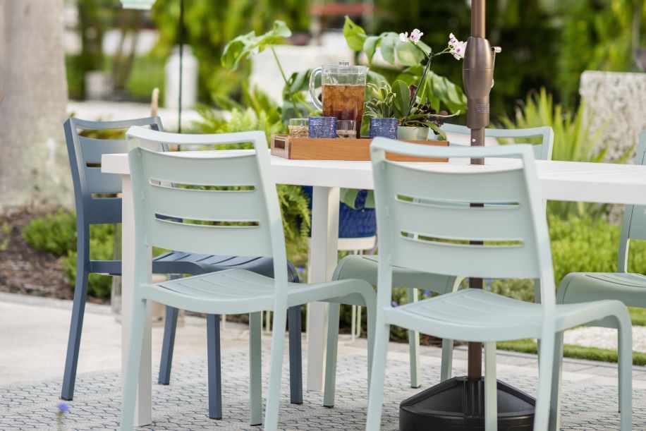 Outdoor dining set with light blue chairs and a white table.
