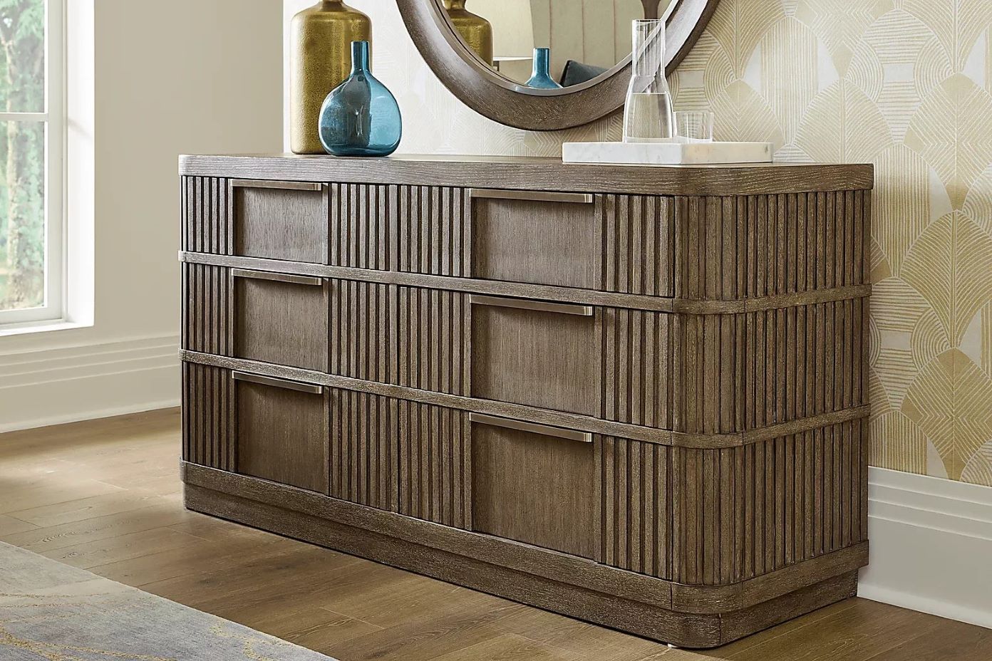 Wooden dresser with three drawers, decorative vertical lines, and metal handles.
