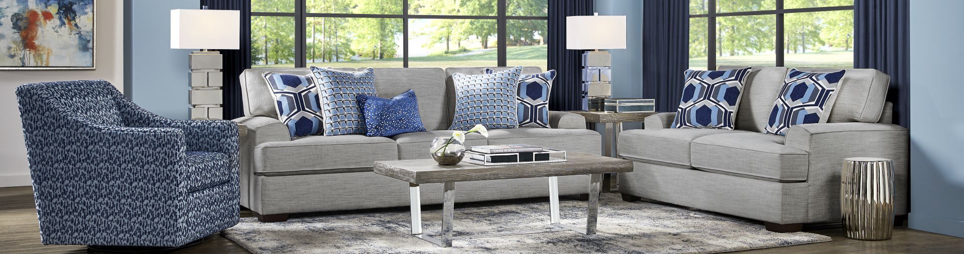 Living room furniture set with a gray sofa, loveseat, and patterned blue chair.

