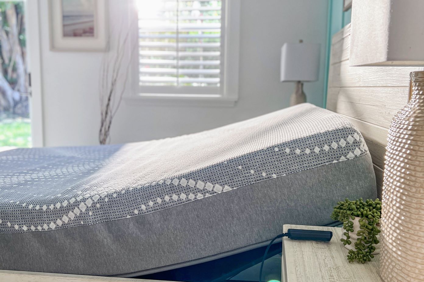 Adjustable bed with a gray and white mattress.
